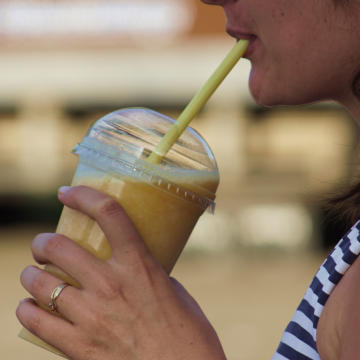 Photograph of a lady drinking a smoothie using a straw